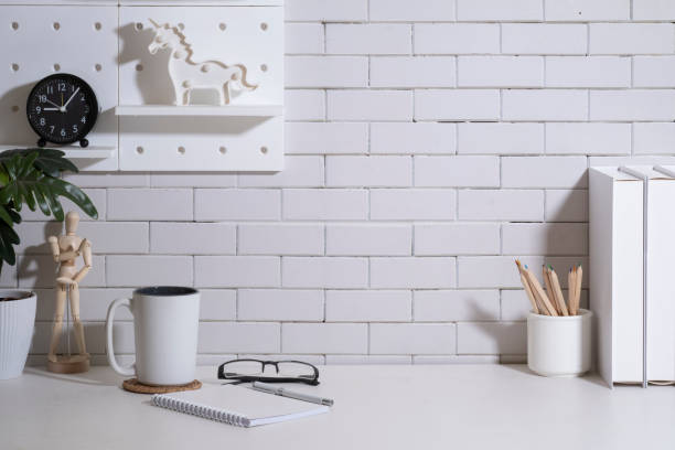 istock Comfortable workplace with coffee cup, smart phone, potted plant and stationery on white table. 1440629495