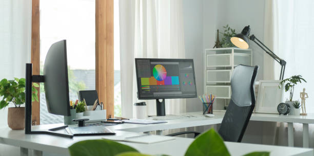 istock Modern office workplace with computers, graphic tablet and supplies  on white table. Graphic design studio. 1440632934