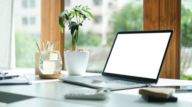 istock Comfortable home office. Laptop computer, stationery and potted plant on white table. 1440633448