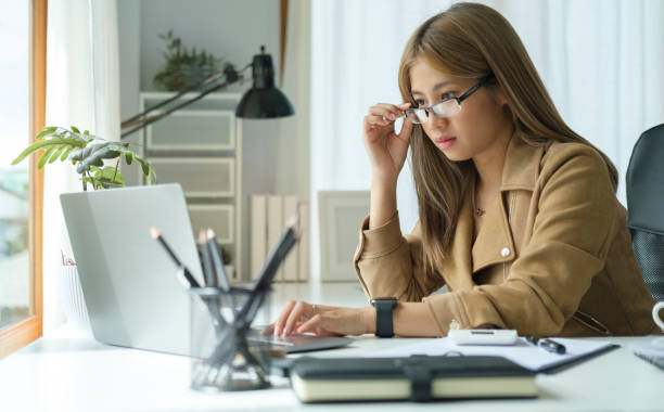 istock Beautiful asian businesswoman using laptop computer and checking financial document at office desk. 1440633457