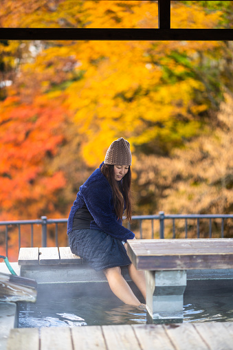 A woman  free hot spring foot bath in a public park in the mountains of North Japan.