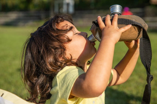 istock Little girl drinking water from canteen 1440637039
