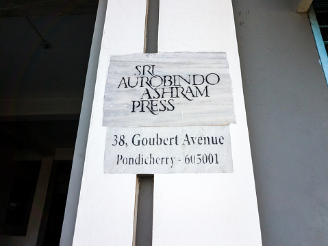 Pondicherry, India - January 2020: The signboard at the entrance to Sri Aurobindo Ashram Press at Goubert Avenue in the old heritage White Town area in Puducherry.