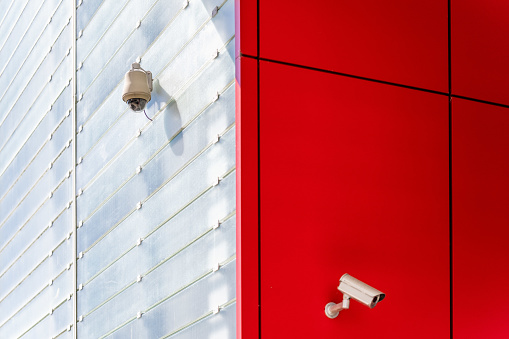 Two security cameras in the corner of the building.