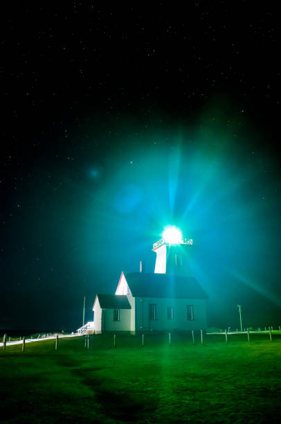 Wood Islands Lighthouse at night Wood Islands Lighthouse at night with green grass, light glare with the stars in the night sky cavendish beach at prince edward island national park canada stock pictures, royalty-free photos & images
