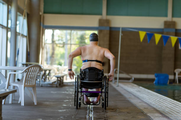 istock Adaptive Athlete Rolling In His Wheelchair By Community Center Pool 1440646678