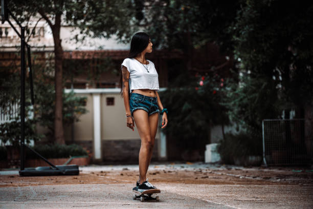 Beautiful Asian girl skateboarding and having fun stock photo