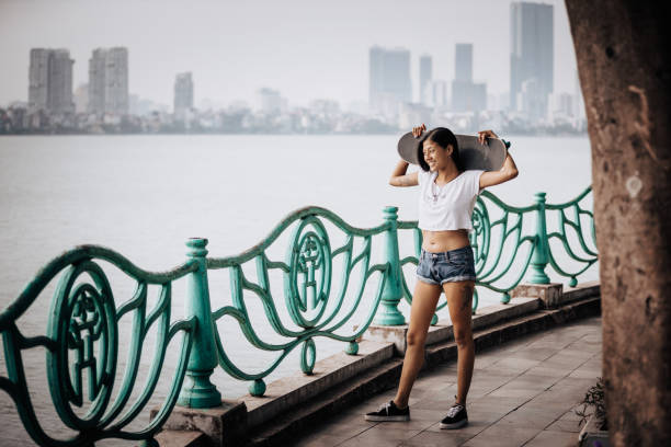 istock Beautiful Asian girl skateboarding and having fun 1440648539