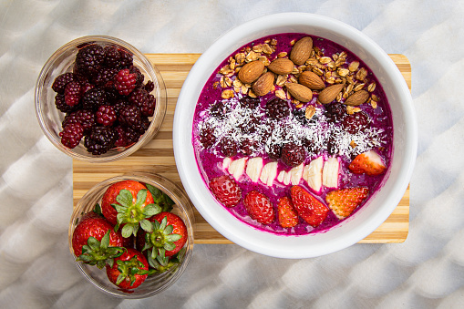 Food Styling Açaí bowl with banana, berries, almonds, strawberries, coconut.