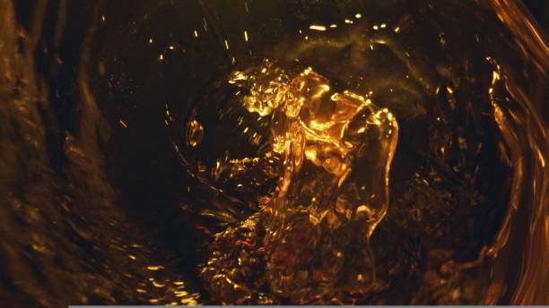 istock Alcohol liquid bubbling glass top view. Craft beer pouring from bottle closeup 1440651925