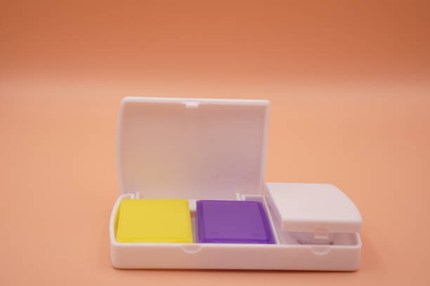 istock Medical: An image showing a tablet cutter cartridge on an orange background, close up. 1440651990
