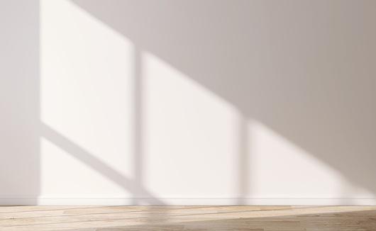 Front view of empty room with white wall, baseboard and wooden parquet floor in sunlight from window for interior design, decoration, architecture and construction mockup