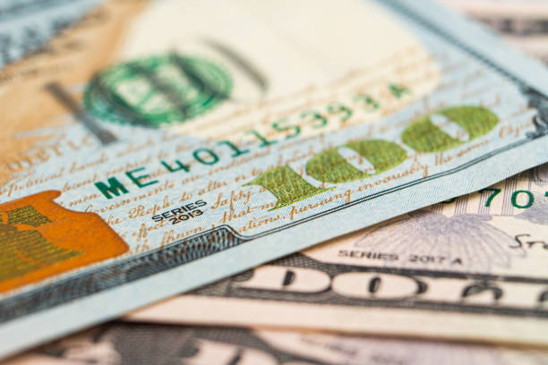 Fragment of hundred dollar banknote. Close-up american paper currancy bill. Selective focus Fragment of hundred dollar note. Close-up american paper currancy. Selective focus. New US paper banknote on pile of old bills. High quality photo one hundred dollar stamp stock pictures, royalty-free photos & images