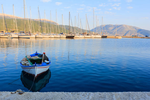 Old fisherman's boat with modern yachts in the dock