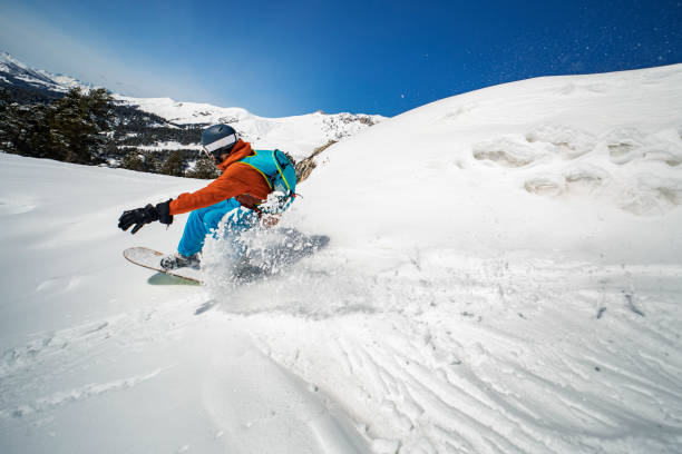 istock Young adult man snowboarding in mountains 1440678562