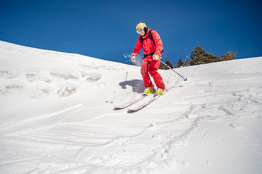 Young adult man skiing in mountains