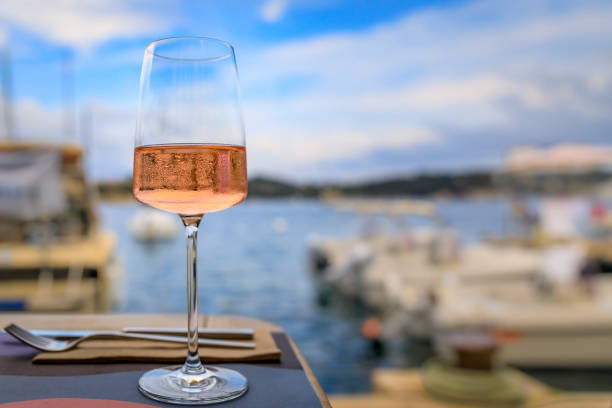 glass of rose wine, mediterranean sea and boats in villefranche sur mer, france - dining nautical vessel recreational boat europe imagens e fotografias de stock