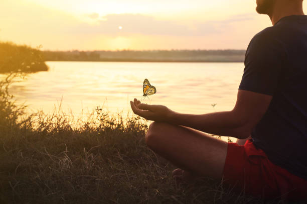 istock Man meditating near river at sunset, closeup. Space for text 1440679819