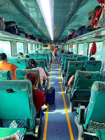 Bijnor, Uttar Pradesh, India - November 7, 2022: Stock photo showing the interior view of an Indian railway carriage with open overhead baggage compartment.