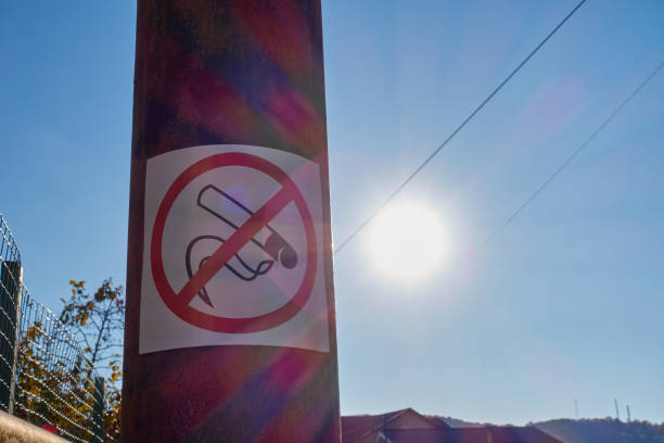 istock No smoking sign on a pole. Bright sunset in the blue sky. 1440681672