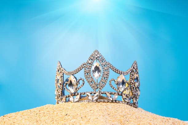 istock Desert Sand Ocean wind Diamond Crown put into Deep blue sky nature hot tropical island for Miss Beauty Pageant Contest Competition, bikini sash high heel shoes hang on outing trip camping background 1440682507