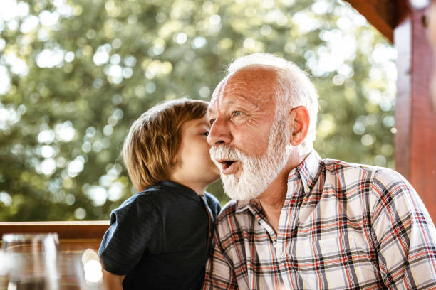 ti sussurrerò qualcosa nonno! - whispering grandparent child grandfather foto e immagini stock