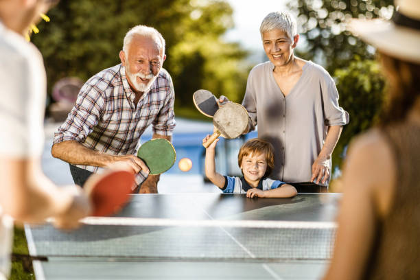 istock Happy extended family having fun while playing table tennis in the backyard. 1440683029