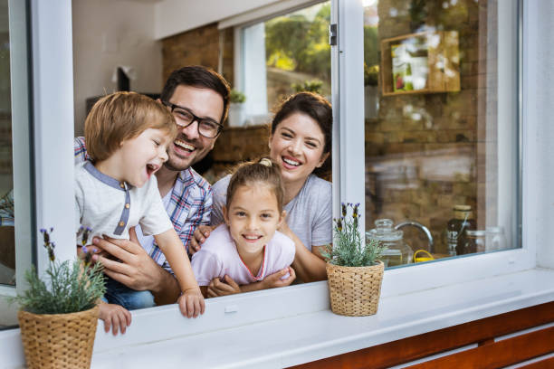 istock Young happy family looking at camera through kitchen window. 1440683122