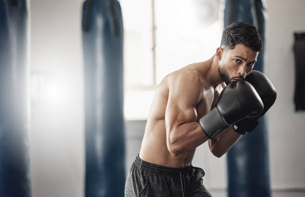 Boxing gym, man portrait and boxer pose technique for protection in mma fight practice studio. Exercise, fitness and athlete focus training for kickboxing safety and wellness preparation. gimnasio de boxeo, retrato de hombre y técnica de pose de boxeador para la protección en el estudio de práctica de lucha de mma. ejercicio, acondicionamiento físico y entrenamiento centrado en el atleta para la seguridad del kickboxing y la preparació