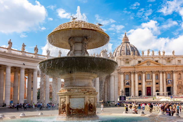 Vatican City, Vatican City State - March 11, 2023: Tourists gathering in st. Peter's square, admiring the splashing fountain and the stunning architecture of the basilica in Vatican city