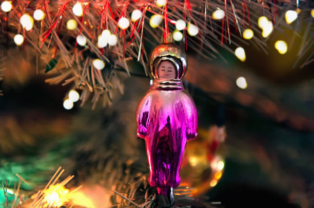 weihnachtsbaumspielzeug in form eines astronauten. ein seltenes retro-spielzeug für einen weihnachtsbaum. geräusche, selektiver weichzeichner, retro-postkarten-styling - red bauble audio stock-fotos und bilder