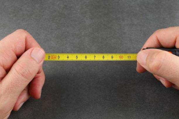 istock Self-retracting metal tape measure in hands. measuring tools 1440693064