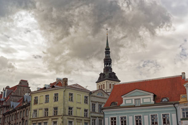 Old residential buildings and spire of Niguliste church against dramatic sky. Tallinn, Estonia