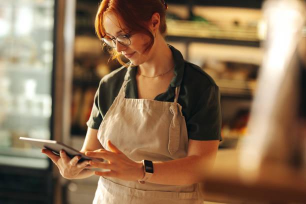 istock Cheerful supermarket owner using a digital tablet in her shop 1440699719