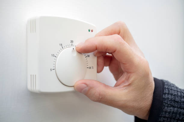 Central Heating thermostat control adjustment saving energy Central Heating thermostat control dial adjustment saving energy fuel crisis thermostat stock pictures, royalty-free photos & images