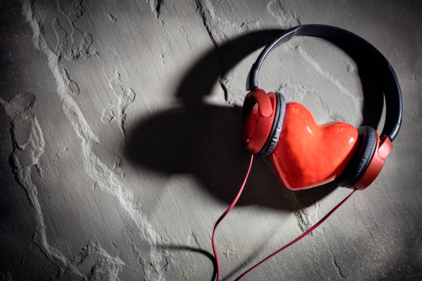Love listening to music, headphones and red heart background stock photo