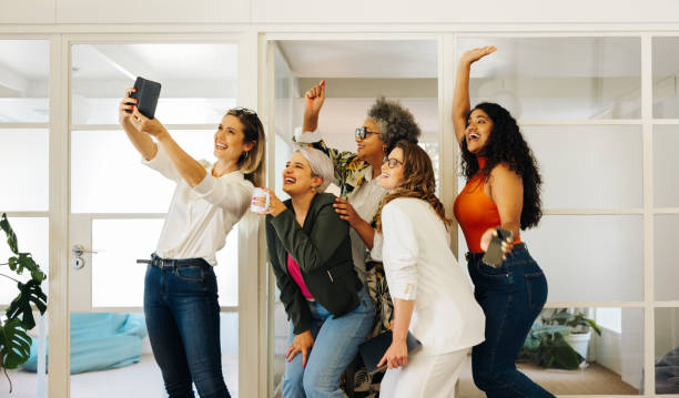 istock Cheerful businesspeople taking a group selfie in an office 1440700614