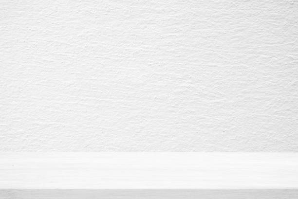 istock Wood Table with White Stucco Wall Texture Background, Suitable for Product Presentation Backdrop, Display, and Mock up. 1440703312