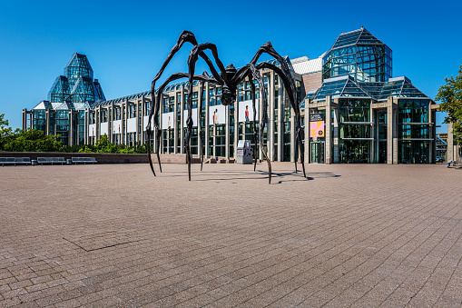 Ottawa, Canada - August 19, 2022: View to spider called Maman and the National Gallery of Canada on Parliament Hill in Ottawa in Canada. Maman (1999) is a bronze, stainless steel, and marble sculpture by the artist Louise Bourgeois.