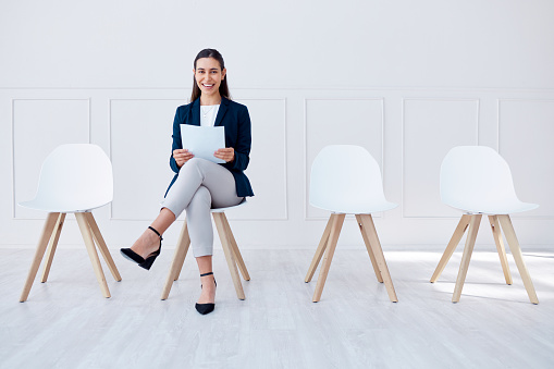 Recruitment, hiring and business woman in waiting room for corporate company or agency job interview. Portrait of happy, smile and confident girl with resume, paper and documents for HR opportunity.