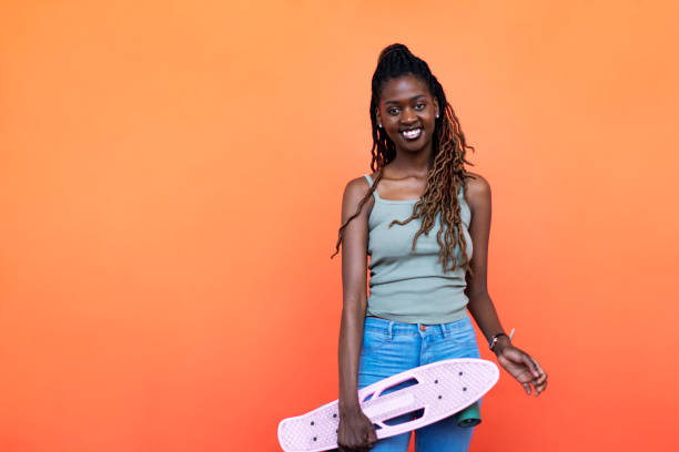 istock Young Black woman with penny board 1440704966
