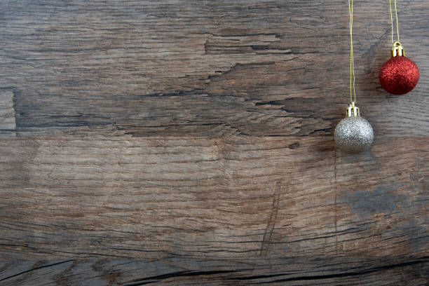 Silver and red Christmas baubles on rustic wooden background