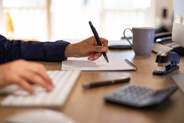 istock Accountant hand types on a calculator and  writes notes on a page. 1440707883