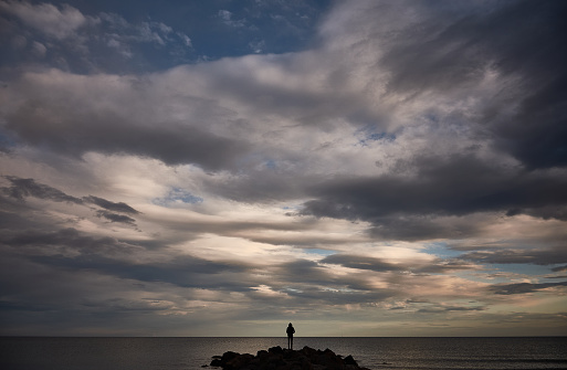 Un hombre contempla el mar Mediterráneo desde las rocas de la Plage Baleine en Sète. Francia photo