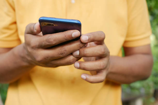 istock young man in yellow shirt using smart phone. 1440710527
