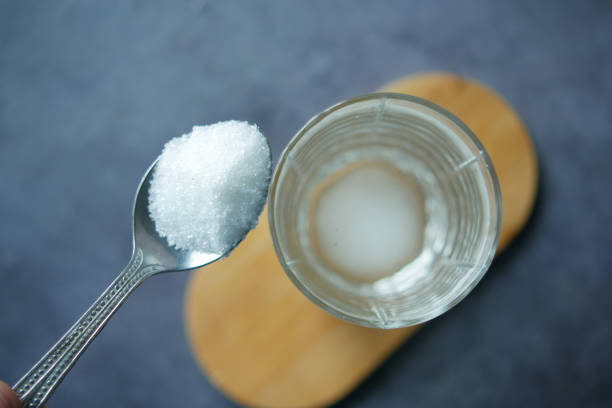 istock pouring white sugar in a glass of water on table 1440710534
