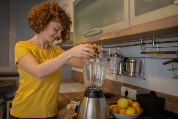 istock Young woman making juice at home 1440712860