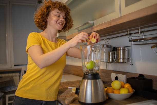 istock Young woman making juice at home 1440712865