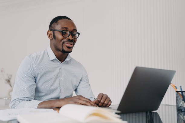 istock Smiling african american man working on laptop on business project, reading email with good news 1440715251