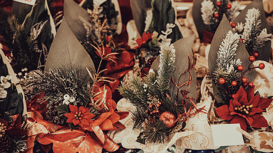 Christmas home decor - Centrepieces with fir branches, holly and flowers in market stall